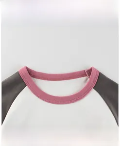 Dettaglio del girocollo a costine rosa con doppia cucitura rinforzata sulla maglia
