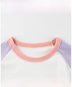 Close-up of raglan sleeve neckline with pink ribbing and contrast color stitching