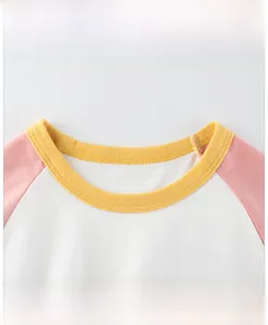 Détail de t-shirt en coton enfant avec manches raglan roses et col côtelé jaune vif