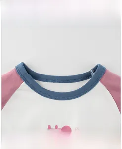 Dettaglio maglietta a maniche lunghe da bambina con maniche raglan e scollo a girocollo