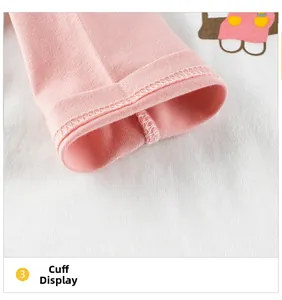 Détail du revers de manche en tricot rose avec des finitions à double surpiqûre