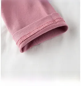 Dettaglio ravvicinato del polsino in maglia di cotone rosa con cucitura a doppio ago