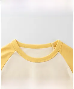 Vue détaillée du col rond jaune d'un t-shirt raglan en coton pour petit enfant