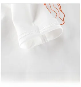 Detail of white cotton long sleeve cuff showing double-stitch hem and orange wavy print