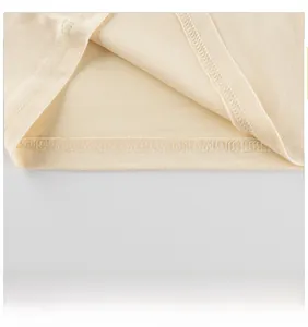 Vue détaillée de l'ourlet à aiguille unique sur un t-shirt pour enfant de couleur crème