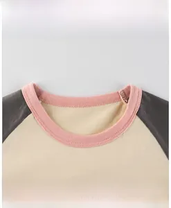 Détail du col d'un t-shirt pour fille avec bordure rose et manches raglan en coton