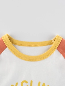Détail du col d'un t-shirt pour fille avec manches raglan et imprimé soleil jaune