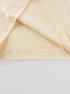 Détail de la couture et de l'ourlet d'un t-shirt à manches longues en coton pour fille