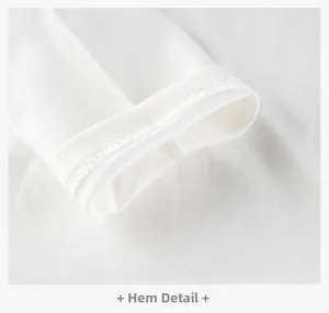 Close-up of high-quality flat-stitched hem on a white cotton knitted kids' long sleeve T-shirt