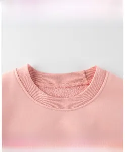 Detail of pink crewneck sweatshirt featuring ribbed collar and soft fleece lining texture