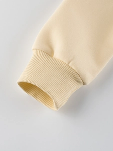Gros plan des poignets côtelés d'un sweat-shirt crème pour filles, polaire d'hiver chaude