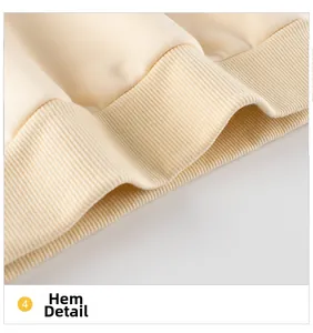 Detailed view of the ribbed hem on a cream-colored cartoon bear hoodie for kids