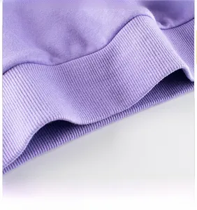 Close-up of the ribbed hem detail on a purple knit sweatshirt for little girls