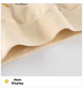 Detail of ribbed hem on beige knitted toddler sweatshirt showing fabric texture