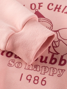 Pink long sleeve girls sweatshirt featuring retro so happy 1986 cartoon print and ribbed cuffs