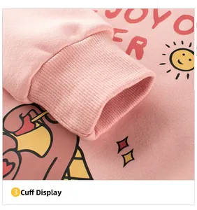 Detail of pink fleece sweatshirt featuring ribbed cuffs and colorful cartoon prints