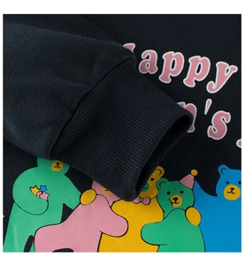 Detail of black fleece sweatshirt featuring colorful bear prints and ribbed elastic cuffs