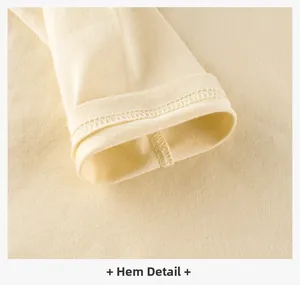 Macro shot of twin needle hemming detail on cream yellow cotton knit t-shirt hem