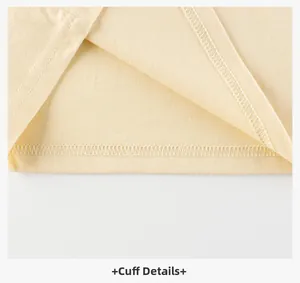 Close-up of double-stitched cuffs on a light yellow cotton long-sleeve kids' shirt