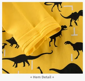 Close-up of double-stitched hem on yellow cotton long-sleeve kids T-shirt with dinosaur print