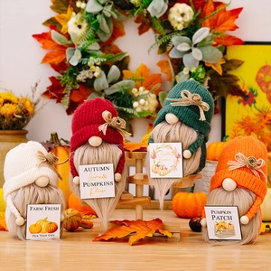 Detail van vier herfstkabouters met gebreide mutsen en pompoen wenskaarten op houten trap