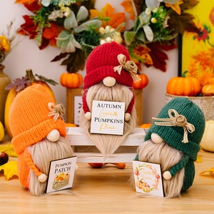 Detail van drie herfstkabouters met gebreide mutsen en bordjes op een witte plank