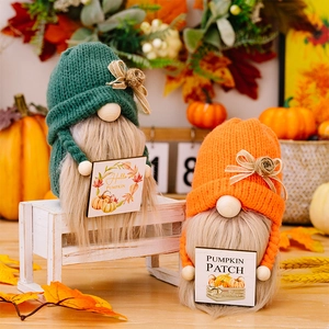 Macro-opname van herfstkabouters met gebreide mutsen en houten Hello Pumpkin bordjes