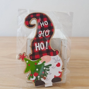 Detail van houten kerstkabouter met HO HO HO-tekst in een plastic verpakking