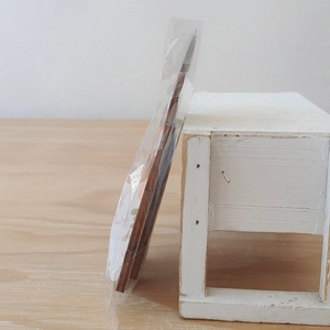Detail van de houten kabouter decoratie in plastic verpakking voor de kerstboom DIY