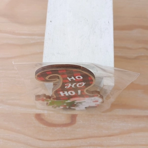 Detail van houten kerstornament met rood-zwart ruitpatroon en HO HO HO tekst