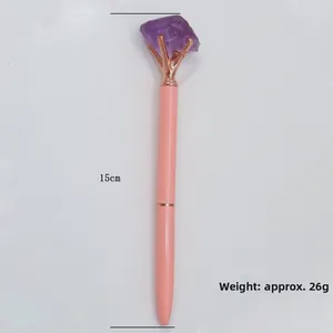 Detail view of 15cm pink ballpoint pen with large raw purple crystal top and rose gold claws