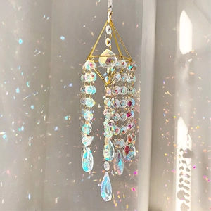 Detail of gold geometric suncatcher showing radiant rainbow light spots on wall