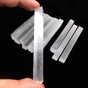 Close-up of natural white selenite crystal sticks with fibrous texture on black background