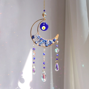 Macro detail of moon evil eye suncatcher with crystal prisms and blue crushed stones