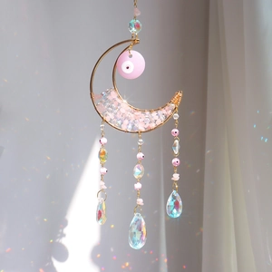 Pink moon suncatcher with crystal stones and evil eye pendant creating rainbow reflections