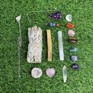 7 Chakra helende kristallen set met salie, amethist, palo santo en stenen op gras