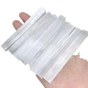 Natural white selenite crystal sticks held in hand for energy healing and home decor