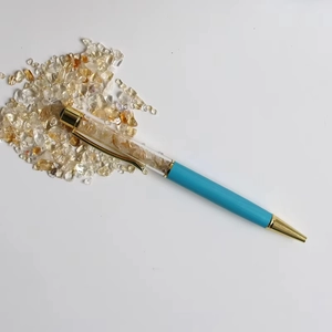 Detail of blue crystal ballpoint pen with yellow gemstone chips and gold accents