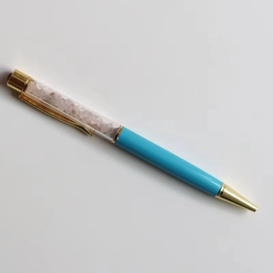 Detail of creative crystal ballpoint pen featuring pink quartz stones and gold accents