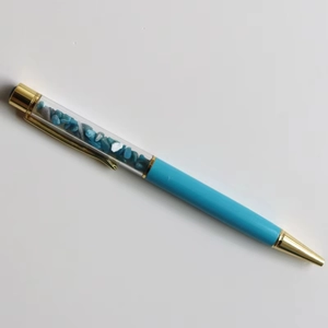 Detail of creative ballpoint pen featuring blue crystal stone filling and gold metal accents