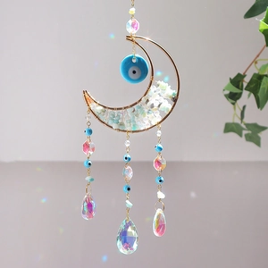 Détail d'un attrape-soleil lune avec œil grec, pierres et reflets arc-en-ciel colorés