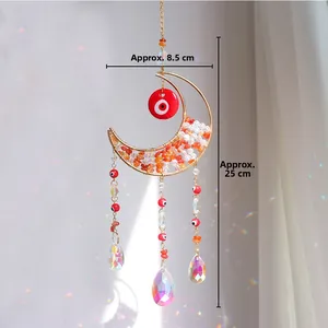Detail of moon sun catcher with colorful crystals, evil eye decor and rainbow reflections
