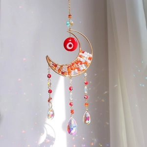 Golden moon suncatcher with red evil eye and colorful crystal prisms creating rainbows