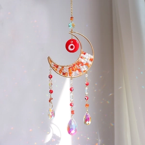 Golden crescent moon suncatcher with red crystal gravel and evil eye charm pendant