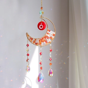 Detail of moon-shaped suncatcher with orange crystals, evil eyes and prism pendants