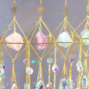 Detail of crystal suncatchers with raw amethyst and geometric gold metal frames