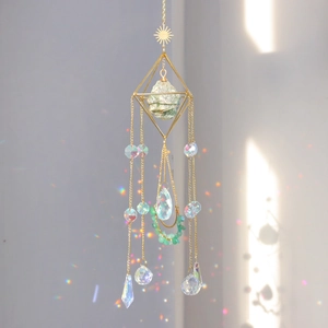 Detail of golden sun catcher with green raw crystal and rainbow light prisms