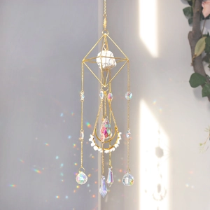 Detail of crystal suncatcher with golden moon geometric frame casting rainbow reflections