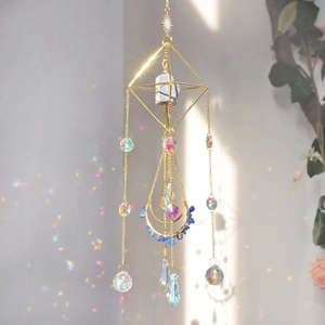 Detail of golden geometric sun catcher with blue raw stone and crystal prisms
