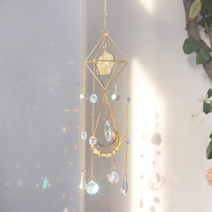 Close-up of golden geometric sun catcher with raw citrine and crystal prisms casting rainbows